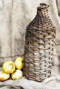 Royalty Free Photo of a Woven Bottle and Apples