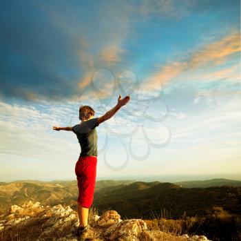 Royalty Free Photo of a Woman Standing on Top of a Mountain