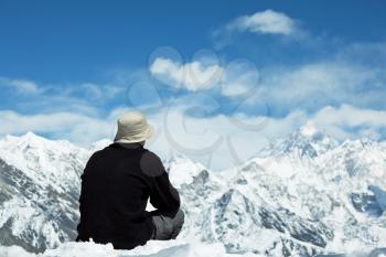 Royalty Free Photo of a Man Sitting on a Mountaintop