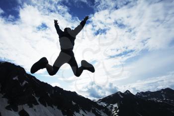 Royalty Free Photo of a Person Jumping in the Mountains