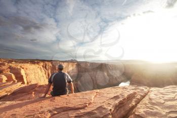 Royalty Free Photo of a Man Sitting on a Rock Cliff