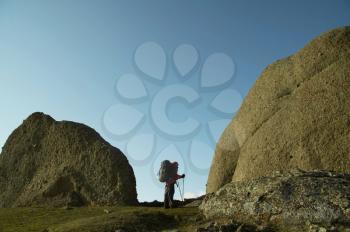 Royalty Free Photo of a Backpacker Looking at a Boulder in the Crimean Mountains