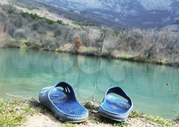 Royalty Free Photo of Sandals Beside a Mountain Lake