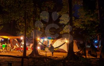 Amazing scene in night camping -girl in hammock on tents background