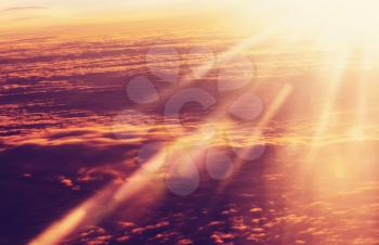Beautiful blazing sunrise landscape above clouds. View from aircraft. Sunset and sunrise concept background.