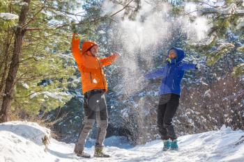 Young boy and girl in winterwear enjoying snowfall in the forest