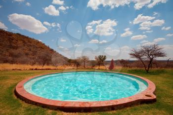 Man jums into the swimming pool in african camping