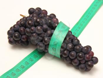 grapes with measure tape on white background