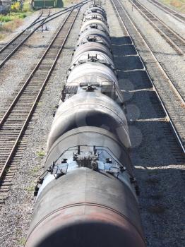 Tanks with oil stand in a row at railway station having extended afar.