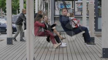 MOSCOW - AUGUST 26: People swing on a swing in city park on August 26, 2017 in Moscow, Russia.