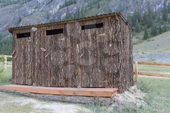 Wooden toilet outdoors in a mountainous area.