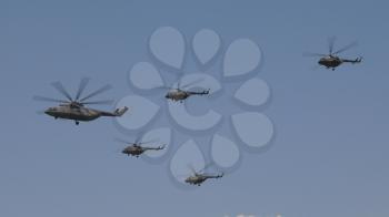combat helicopters Mi-26 and Mi-8 fly in sky on training parade in honor of Great Patriotic War victory.