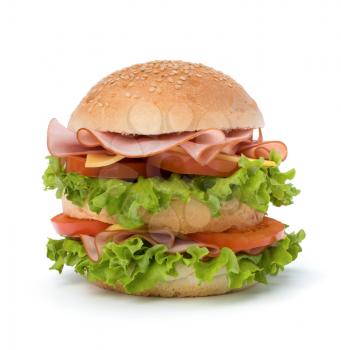 Big appetizing fast food sandwich with lettuce, tomato, smoked ham and cheese isolated on white background. Junk food hamburger.