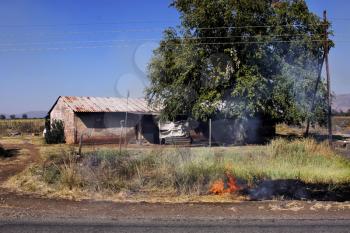 Royalty Free Photo of a Fire Close to Rural Houses
