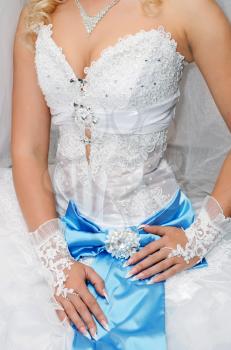 bride is in white dress with a blue bow