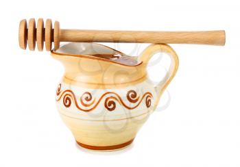 honey in a jug and wooden stick isolated on white background