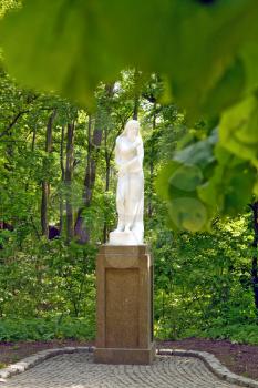 white sculpture in a park in surroundings a foliage