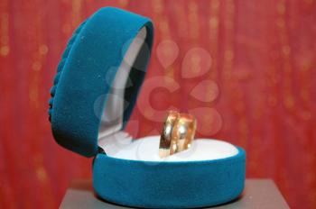 weddings rings in a blue box a red background