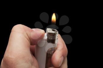 hand with a cigarette lighter on a black background