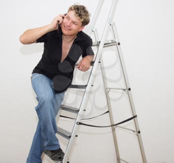 a man with a cell on a stepladder on a white background