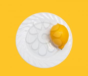 lemon in a white plate on a yellow background