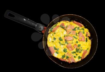 scrambled eggs with sausage in a skillet over a black background