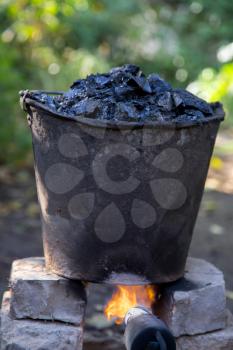 a bucket of tar on the fire, for roof repairs