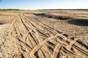 Car track on the sand in the desert .