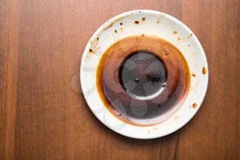 saucer with a dried coffee on a wooden background
