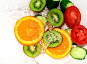 fresh fruits and vegetables in water on a white background