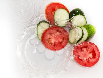 cucumber and tomato in water on white background