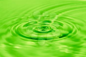 a drop of water falls into the green water