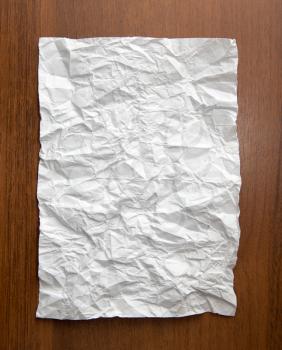 crumpled white paper on the wooden background