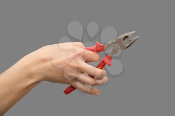 pliers in hand on gray background