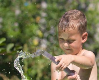 boy squirting water from a hose