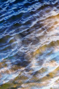 sky with clouds reflected on the water surface with waves