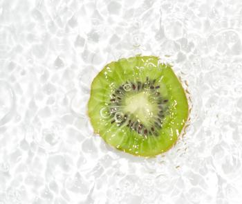 juicy kiwi fruit in water on a white background. macro