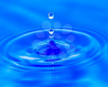 water droplets falling in blue water