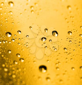 golden water drops on glass