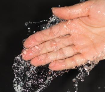 hand in water on a black background