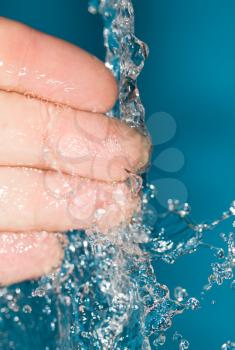 fingers in water on a blue background
