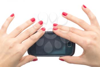 Elegant female hands with red nails holding a smart phone. Closeup isolated on white