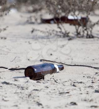 Glass bottles in the sand on nature. trash