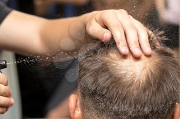 spraying with hair spray in beauty salon