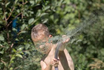 boy squirting water from a hose