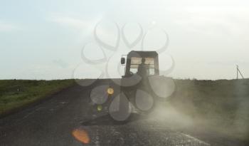 tractor on the road at sunset