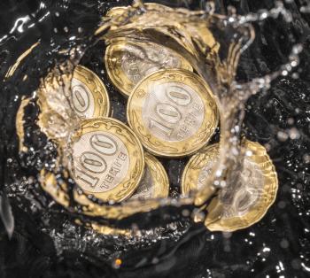 coins in water splashes on a black background