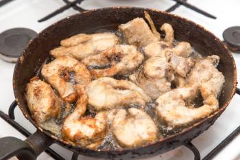 fish is fried in a pan in butter