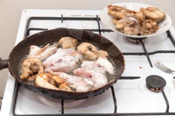 fish is fried in a pan in butter