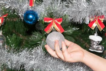 toy on the Christmas tree in a child's hand for the New Year